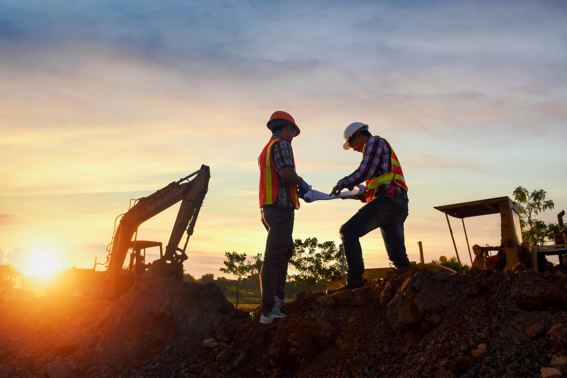 Trabajadores de la construcción revisando planos en obra